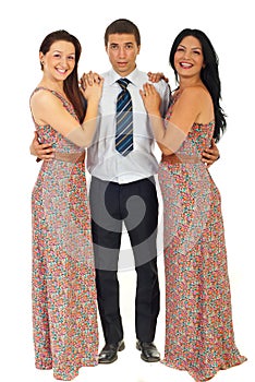 Surprised man holding two laughing women