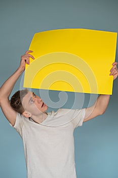 Surprised man holding yellow advertising banner