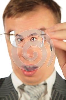 Surprised man peers into spectacles