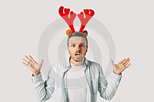 Surprised man in red christmas hat over grey background