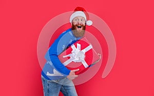 surprised man in santa claus red hat with new year present. new year sale. santa man hurry up