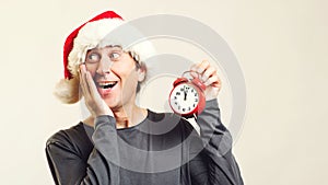 Surprised man in Santa helper hat with clock. Last minute christmas shopping. Time is coming. New Year and Christmas. Christmas