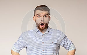 Surprised man with shocked look on studio background