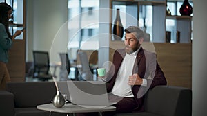 Surprised man staring computer screen coworking interior. Businessman rejoicing