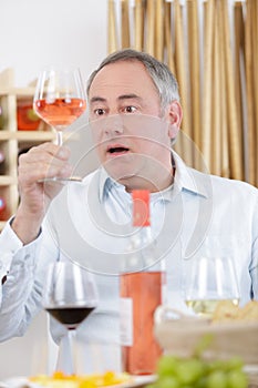 Surprised man tasting glass rose