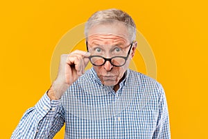 Surprised mature man in glasses staring at camera