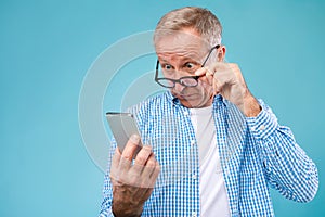 Surprised mature man using mobile phone, looking at screen