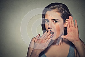Surprised nosy woman with hand to ear gesture listening photo