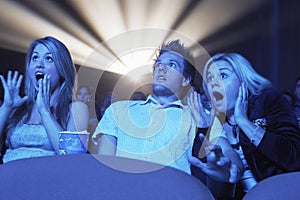 Surprised People Watching Horror Movie In Theatre