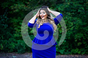 Surprised plus size fashion model in blue dress outdoors, beauty woman with professional makeup and hairstyle