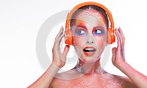 Surprised pretty woman with headphones listening to music