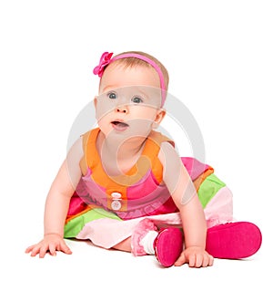 Surprised, sad little baby girl in bright multicolored festive d