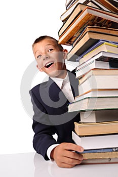 surprised schoolboy with huge stack of books