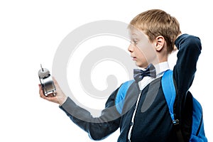 surprised schoolboy watching time on alarm clock, portrait isolated