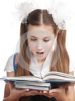 Surprised schoolgirl reading textbook.