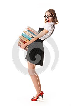 Surprised schoolgirl on a white background with a pile of books