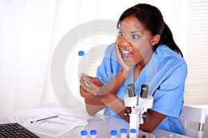 Surprised scientific woman looking to test tube