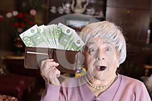 Surprised senior woman with full wallet