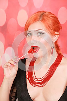 Surprised sexy girl eating lollipop. Beauty Glamour Model woman with heart shape red sweet.