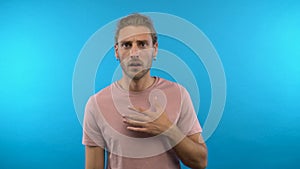 Surprised shocked guy says wow. Man on an isolated blue background. 4K
