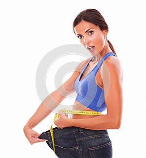 Surprised sporty woman measuring her waist