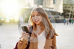 Surprised student girl watching excited her smartphone in city street