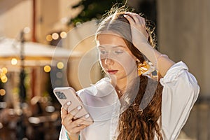 Surprised teen child girl use smartphone loses, bad news, fortune loss fail outdoors in city street