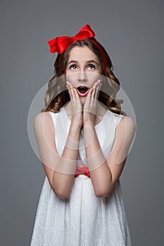 Surprised teen girl with red bow on head