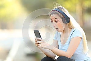 Surprised teenage girl finding music offers on phone