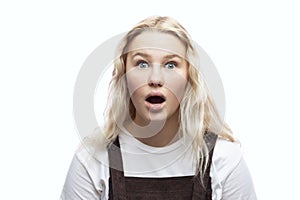 Surprised teenage girl with her mouth open. Cute young blonde with freckles. Isolated on a white background