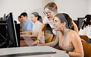 Surprised teenage girls emotionally react to solving problem in computer class