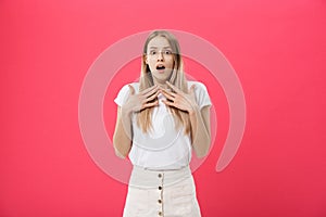 Surprised teenage student girl show shocking expression with something. Isolated on Bright Pink Background. Copy space