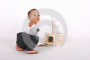 Surprised toddler boy playing with Montessori toy for toddlers