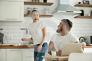 Surprised wife excited to hear news from husband in kitchen