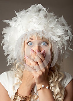 Surprised woman with big blue eyes and a plume hat