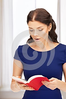 Surprised woman with book