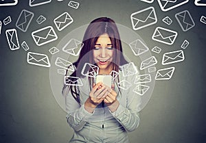Surprised woman busy receiving many messages emails on smart phone photo