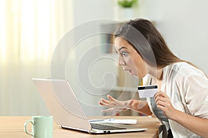 Surprised woman buying on line at home