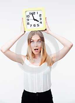 Surprised woman holding big clock