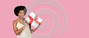 Surprised woman holding a gift with white bow