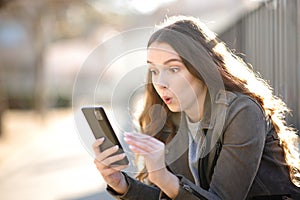 Surprised woman looking at her phone