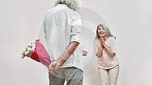 Surprised woman looking at man giving gift to her