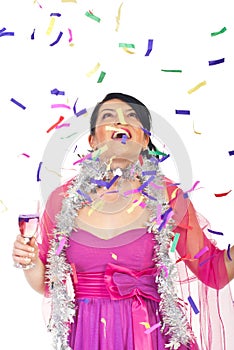 Surprised woman looking up at falling confetti