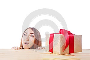 Surprised woman looks at a gift box. Christmas, x-mas, winter, happiness concept.