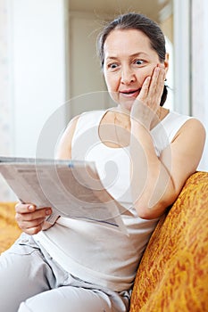 Surprised woman with newspaper