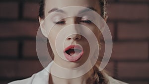 Surprised woman opened mouth from amazement on brick wall background