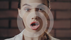 Surprised woman opened mouth from amazement on brick wall background