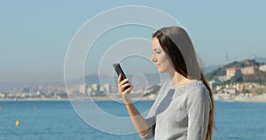 Surprised woman on phone on the beach