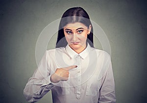 Surprised woman pointing at herself