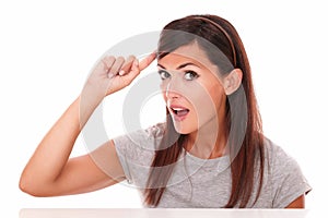 Surprised woman pointing to her head